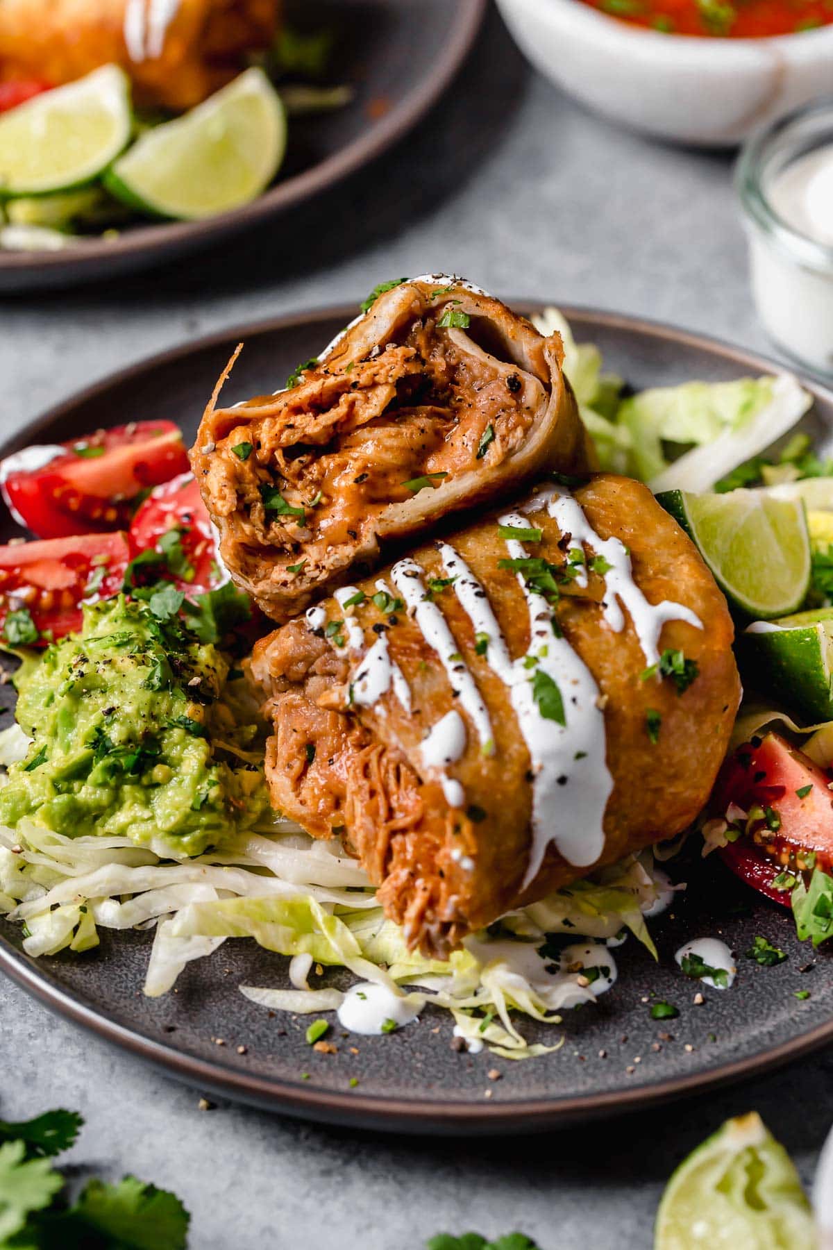 Homemade Chicken Chimichanga cut in half stacked. Filled with refried beans, and seasoned shredded chicken.