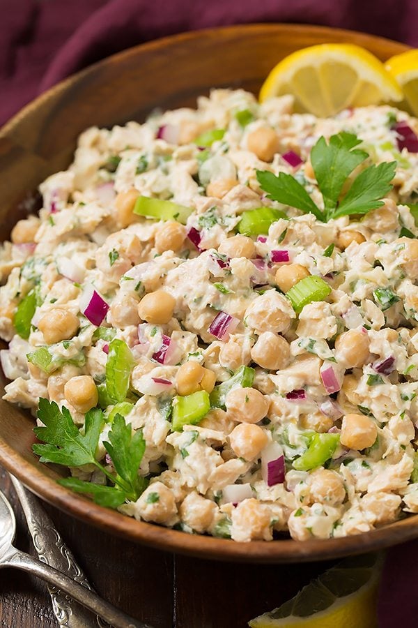 Tuna salad in a wooden serving bowl. It includes albacore tune, chick peas, red onion and a creamy lemon herb dressing.
