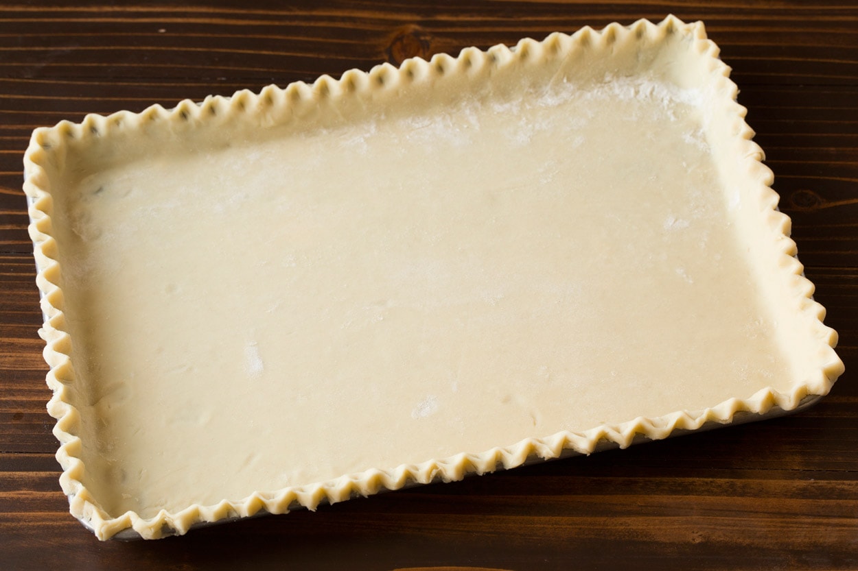 Pie crust for apple slab pie on a rimmed baking sheet before adding filling.