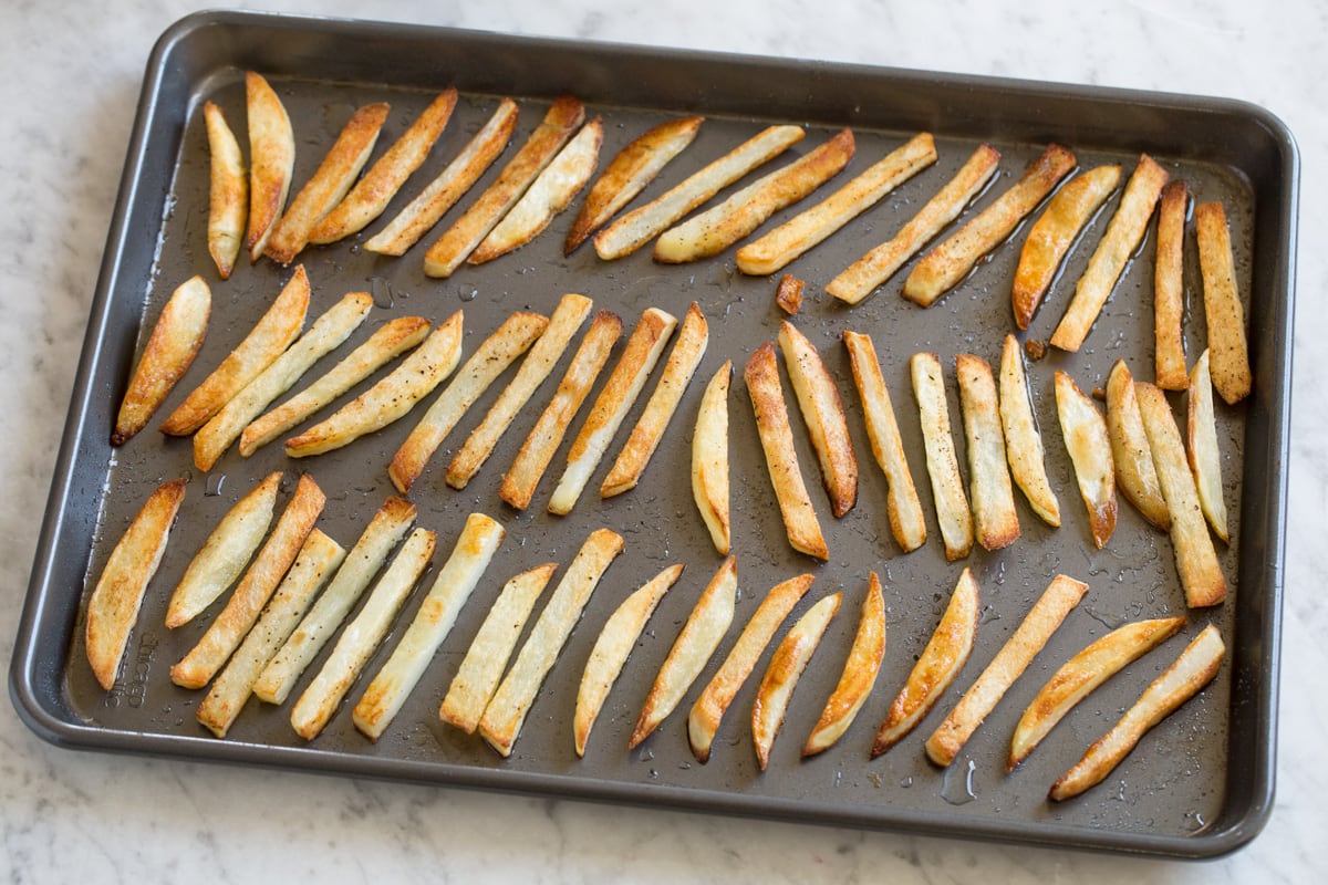French fries after baking in the oven on a baking sheet.