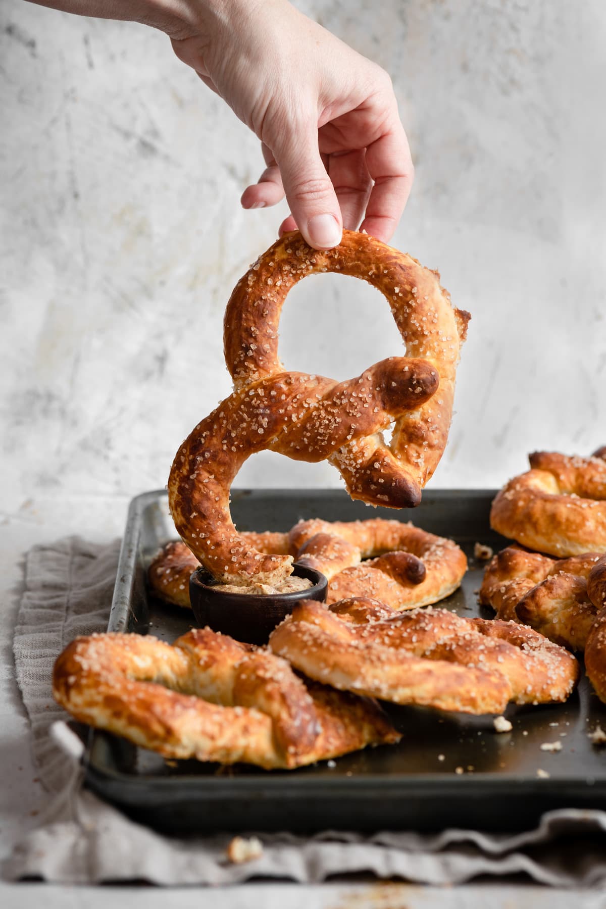 Dipping pretzel into mustard dipping sauce.