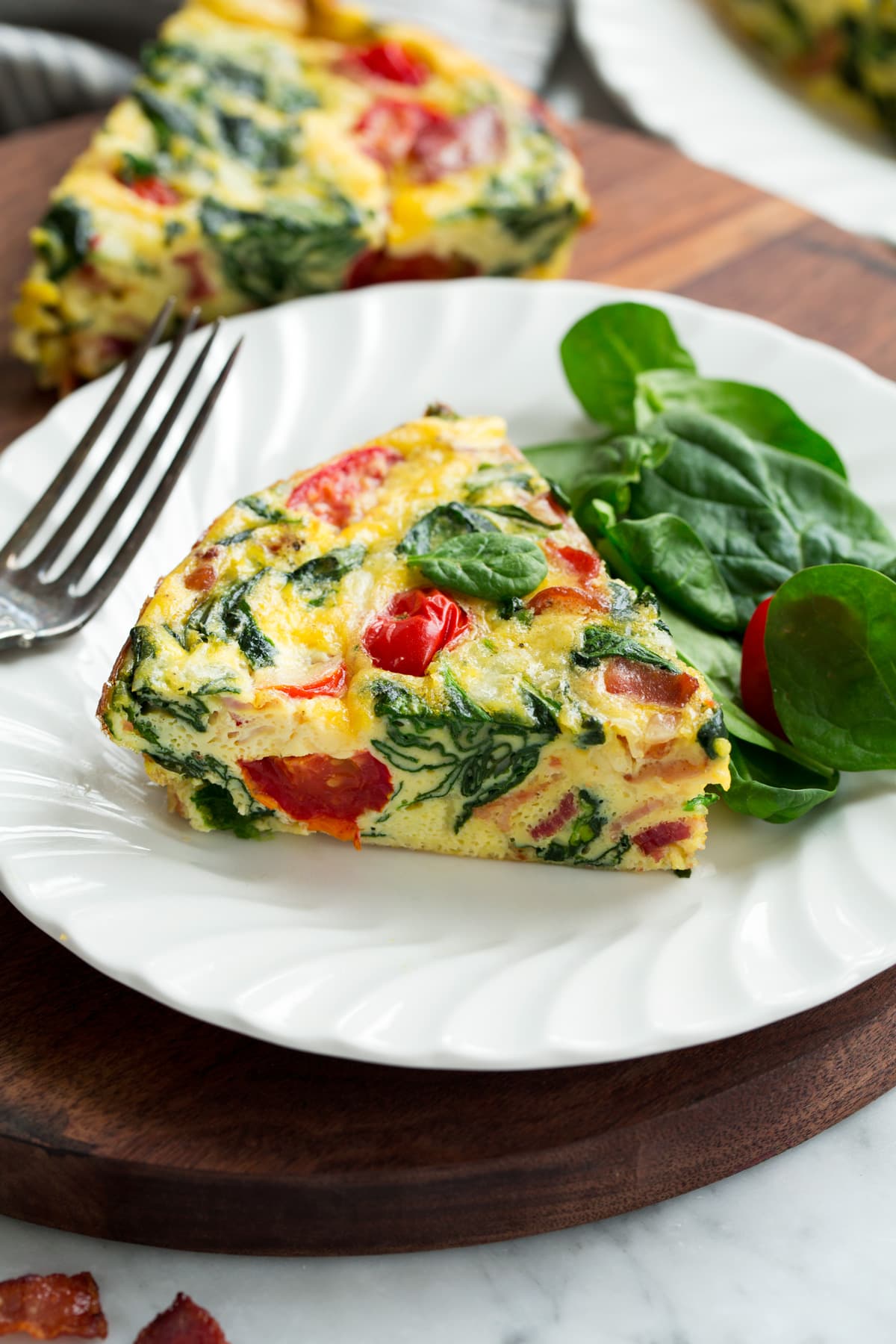 Single slice of frittata on a white serving plate.
