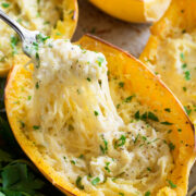 Cheesy spaghetti squash shown with a fork removing a portion.
