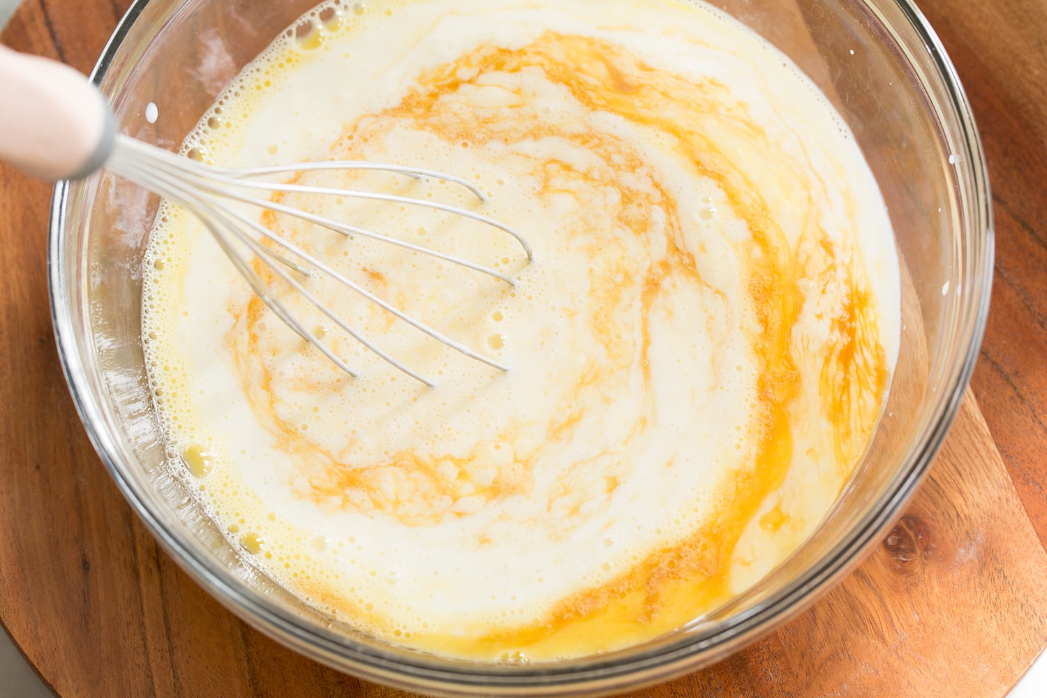 Adding buttermilk to pancakes mixture.