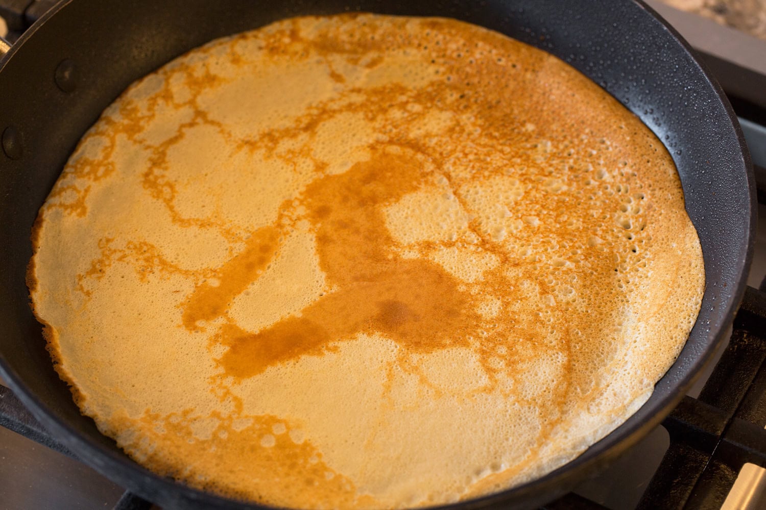 Healthy oat crepe in pan shown after flipping.