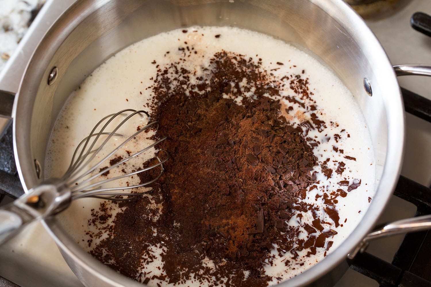 Chopped chocolate added to milk in saucepan.
