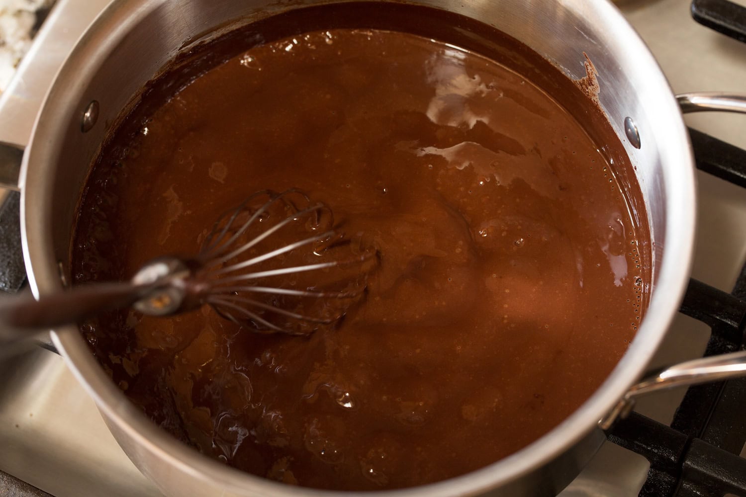 Finished French hot chocolate in saucepan with whisk.